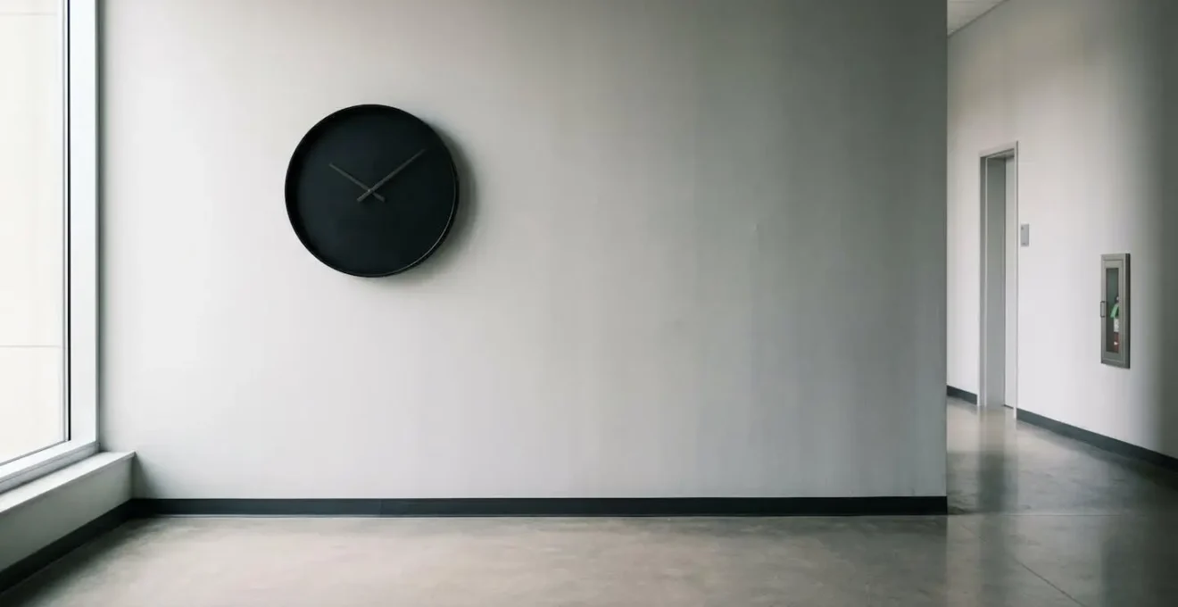 Ambiente minimalista con orologio da parete e luce naturale su superficie neutra